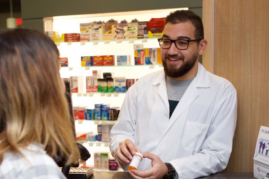 Pharmacy student serves a customer in a retail setting