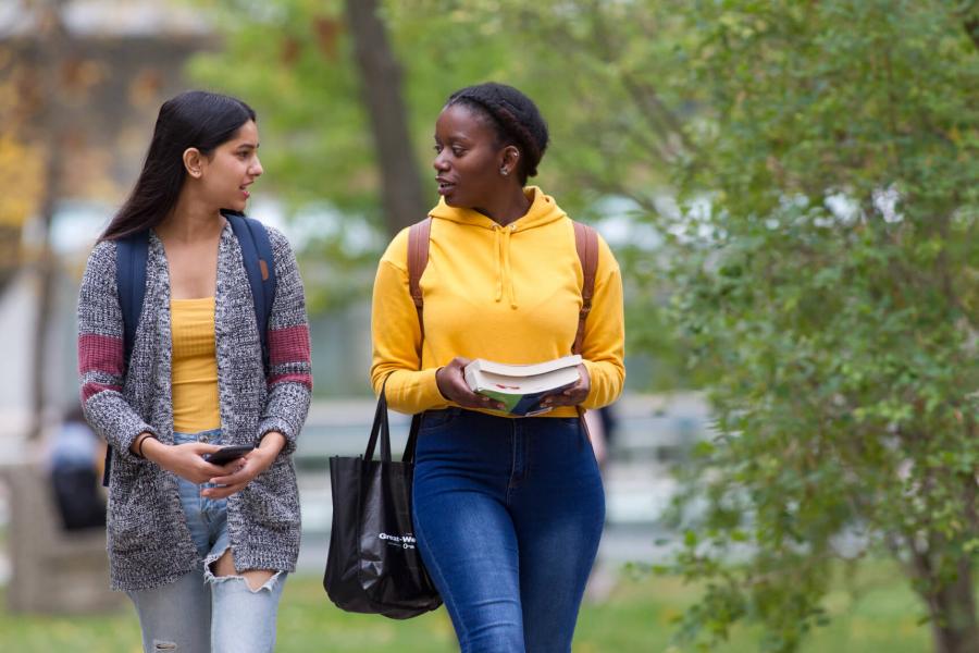 Two students walking together outdoors at the University of Manitoba Fort Garry campus.