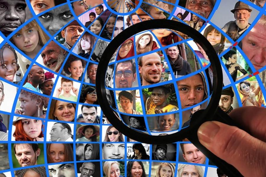An image made of various peoples faces forming a globe.