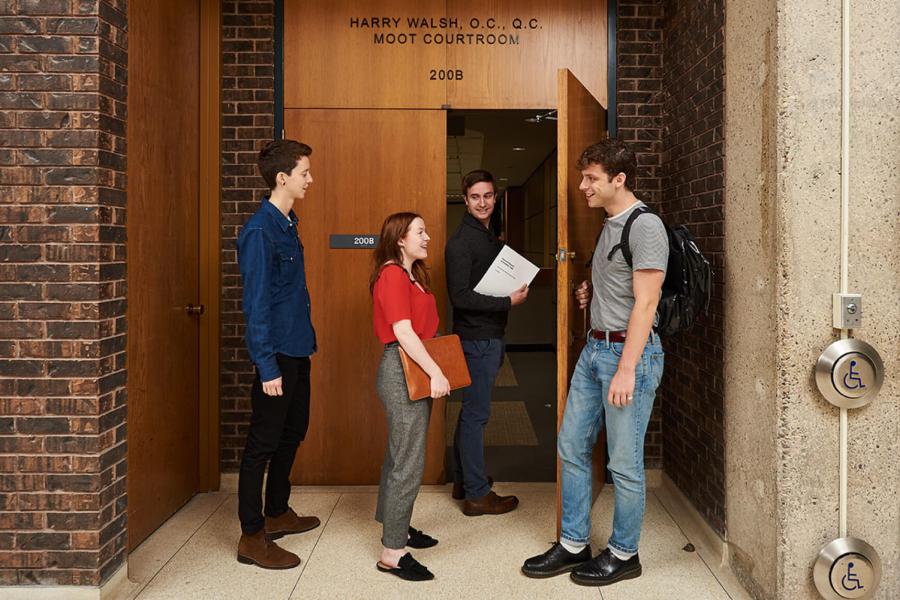 Four students walk into a building together.