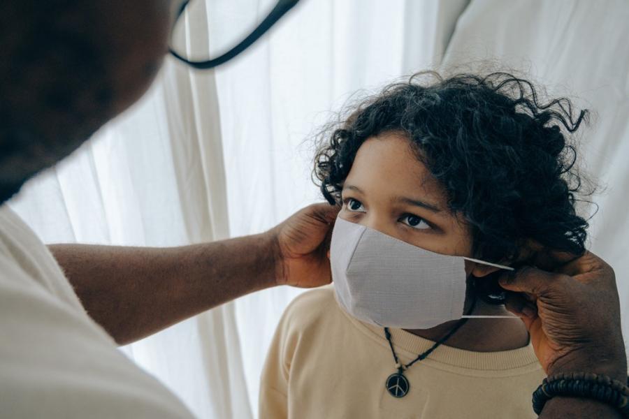 Man puts a mask on a child.