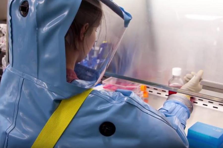 Researcher works in protective clothing.