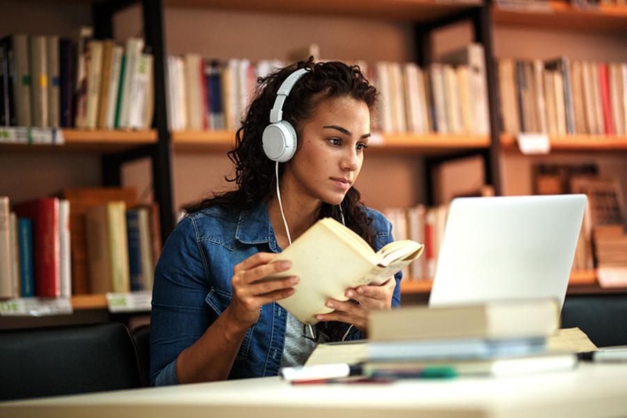 Young female student studying a library.