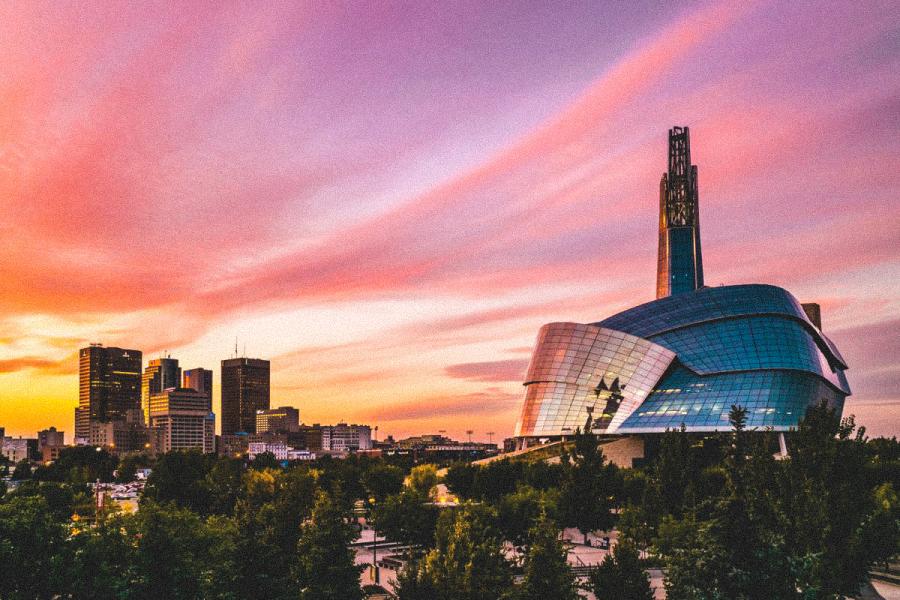 An skyline image of the Museum of Human Rights and downtown Winnipeg during sunset.