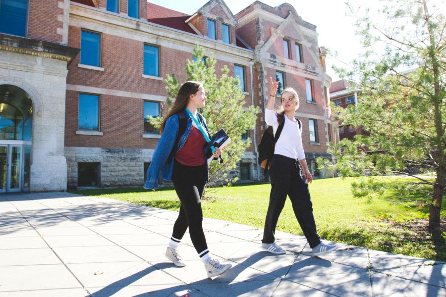 Two undergraduate students walking outside on Fort Garry campus