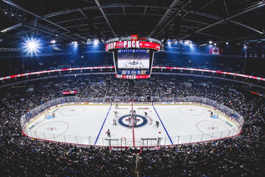 Aerial shot of a centre ice puck drop at Canada Life Centre, with the Jets facing off against the Anaheim Ducks.