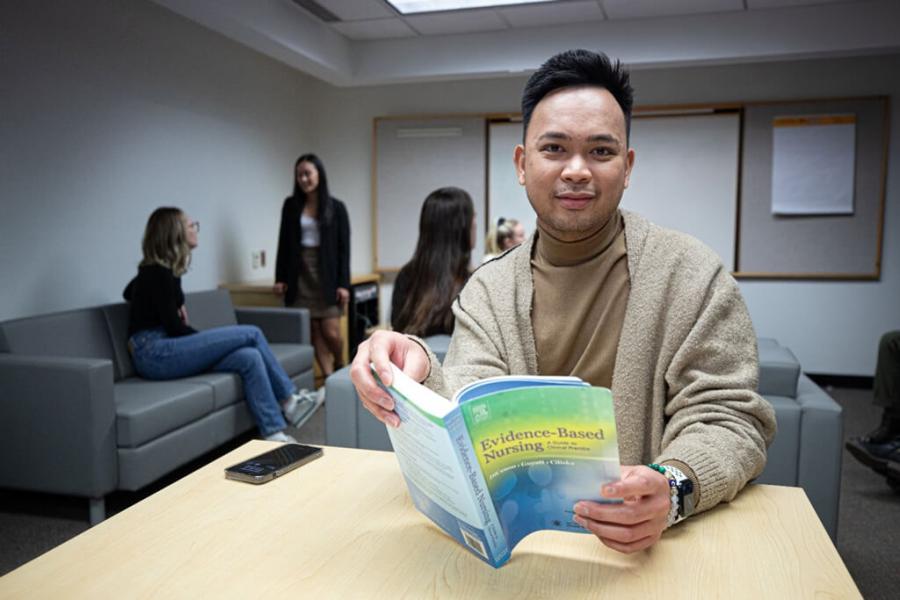 Graduate student at a desk with a book