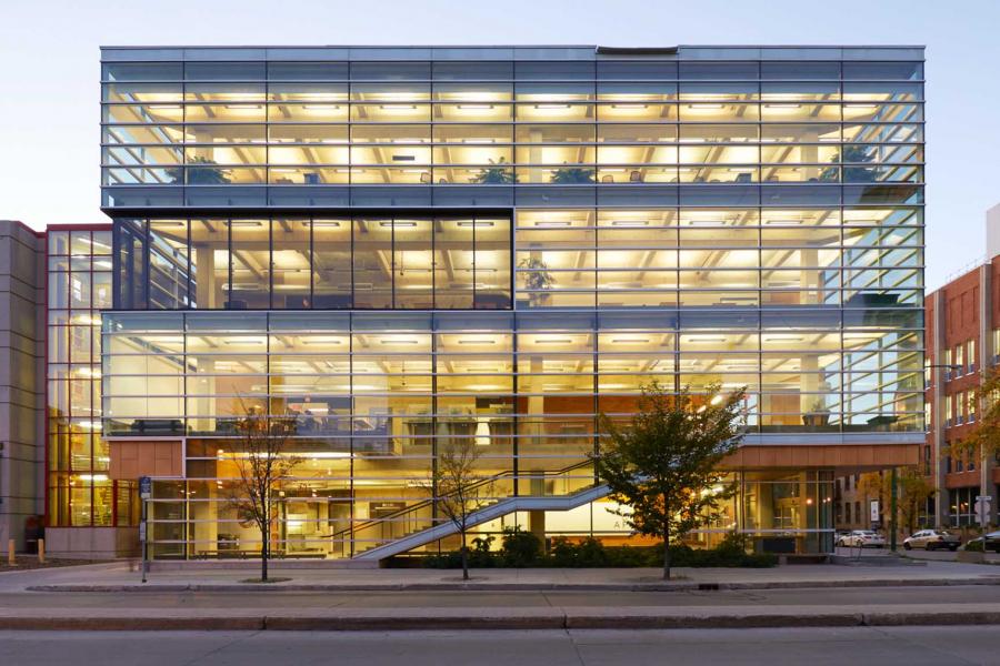 Night time exterior of the Apotex Centre building with lights on.
