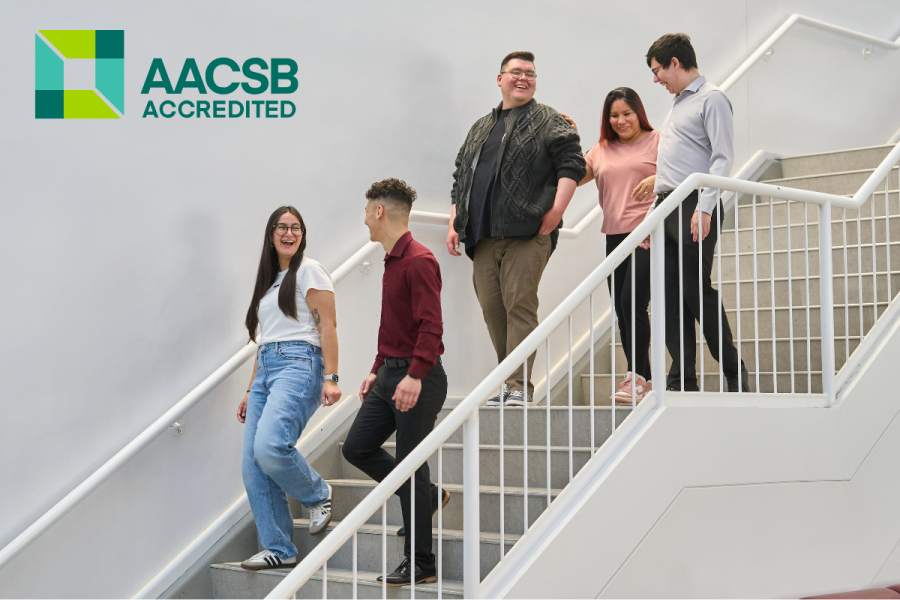 Students walk down the stairs of the Drake Centre; the AACSB logo is juxtaposed.