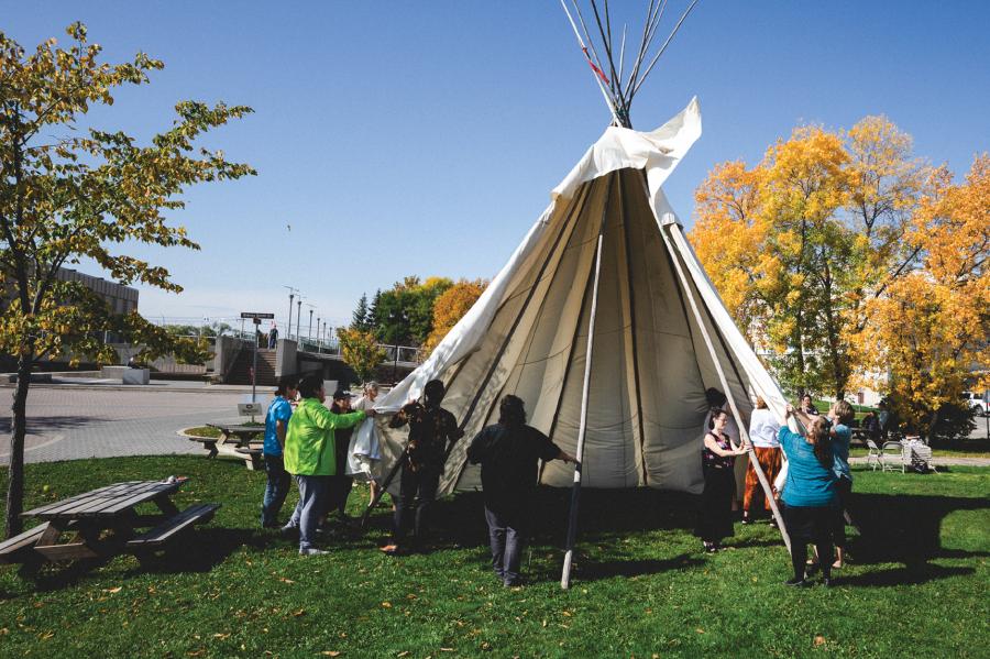 University of Manitoba community setting up a Tipi on Fort Garry campus