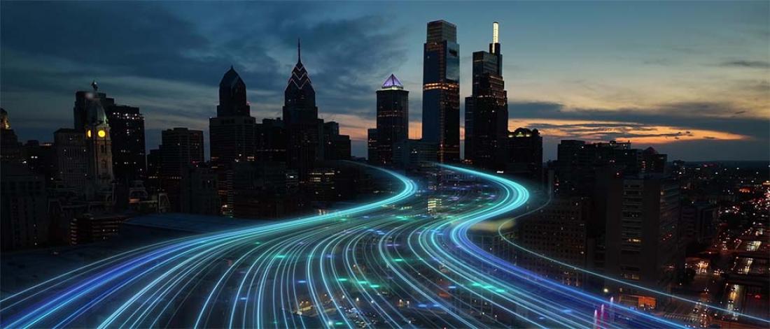 City skyline with glowing digital lines representing high-speed data flow at dusk, showcasing urban technology and connectivity advancements.