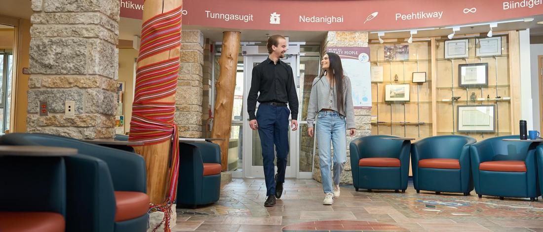 two students walking inside migizii agamik