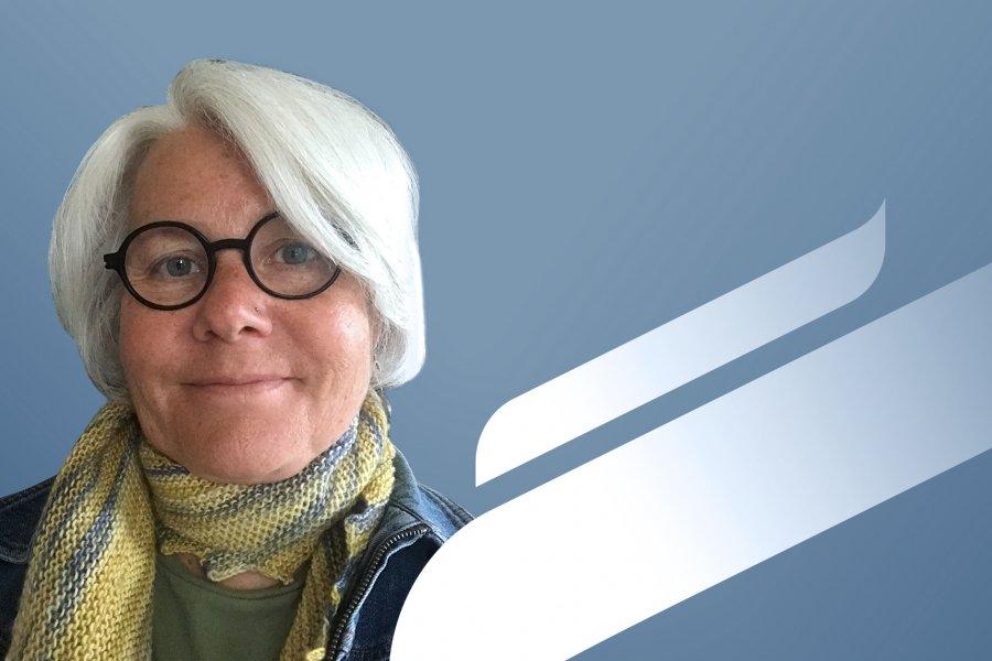 A portrait photo of Charlotte Enns with a blue background.
