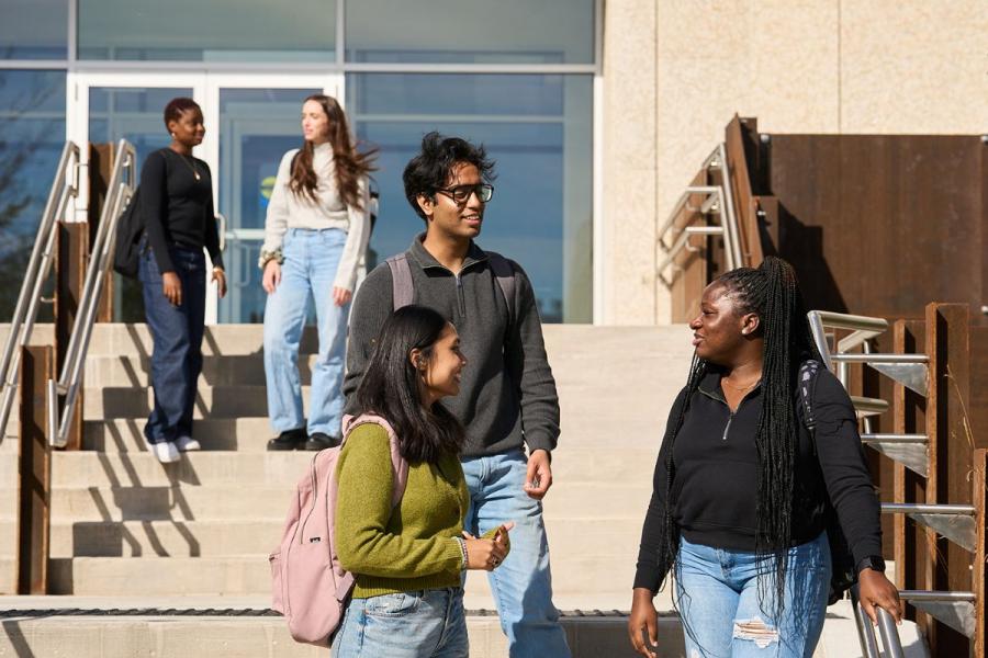 students chatting outside on the stairs of a building