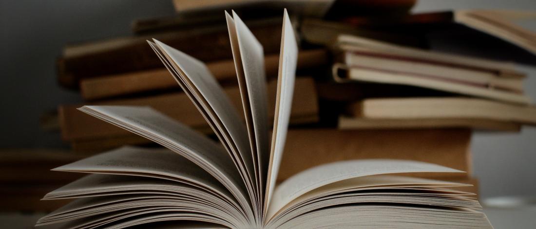 Book opening with more books in the background