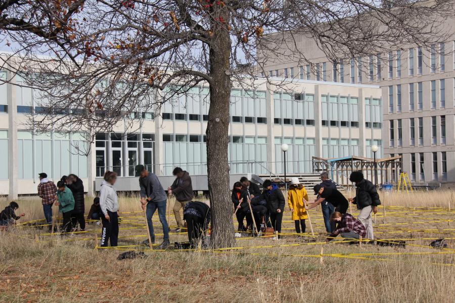 group of people planting in front of a building