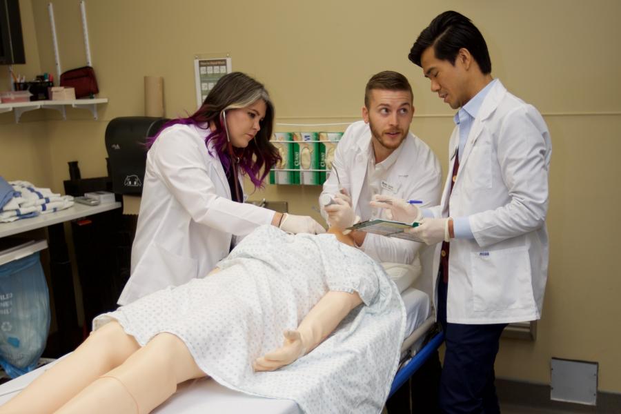 A group of residents work on a medical manikin