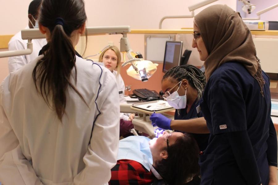 Dental hygiene students work with a patient