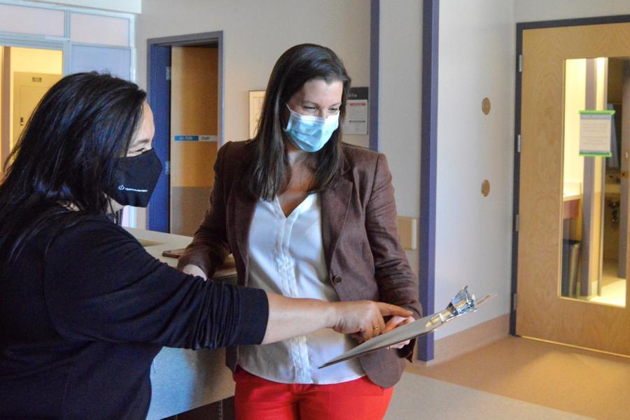 A patient and a physician reviewing a chart in hospital.