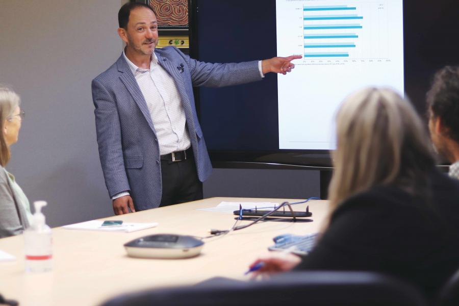 A health researchers is giving a presentation to a group of colleagues.
