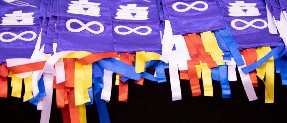 A folded pile of purple Indigenous graduation stoles