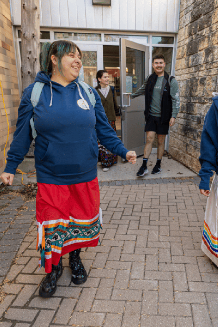 Indigenous students walking together outside Migizii Agamik.