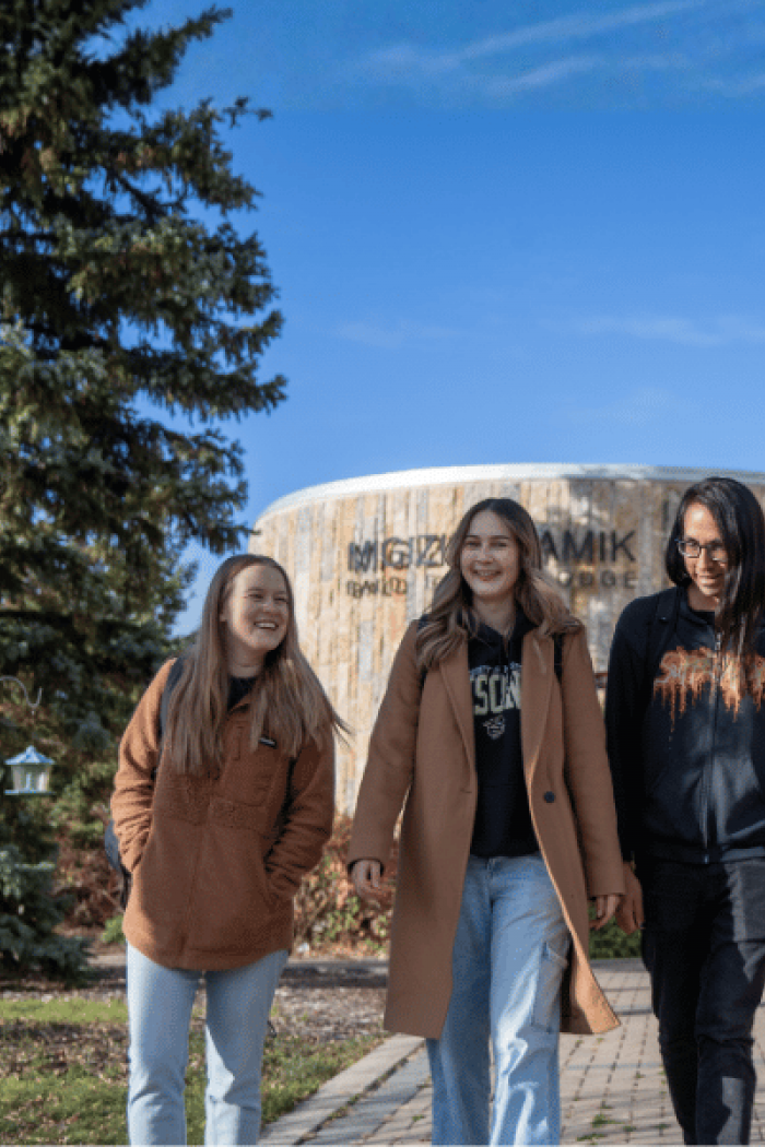Four Indigenous students walking together on the University of Manitoba campus.