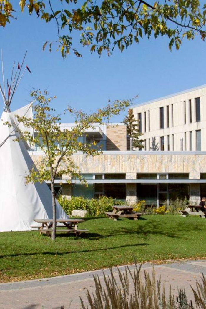 A white tipi on the lawn outside Migizii Agamik.
