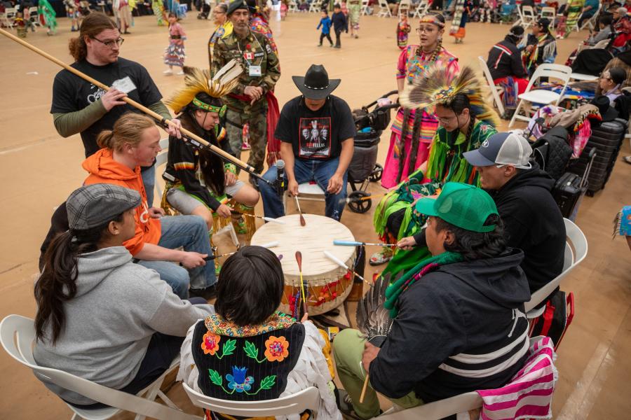 drummers sitting in circle around drum at pow wow