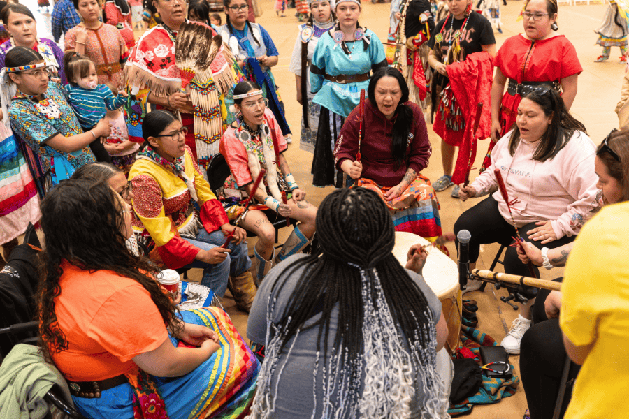 Drum group and singers gathered in a circle at a pow wow