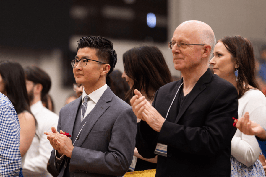 Guests applauding during a graduation pow wow ceremony
