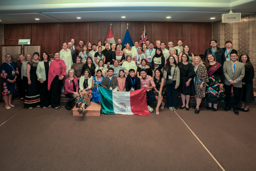 Participants pose with a Mexican flag during the Canada–Mexico Binational Indigenous / Intercultural Roundtable.