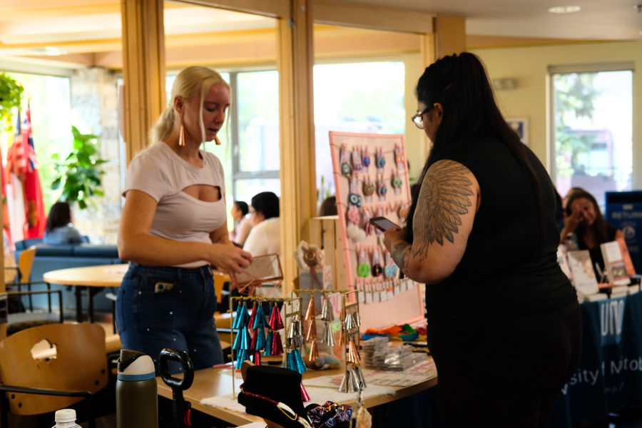 A vendor speaking with a visitor at an artisan market.
