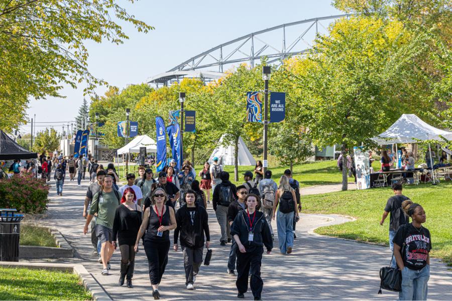 Students walking along a campus pathway during Orientation.