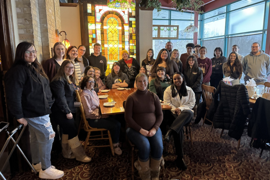 Students gather for a group photo at a restaurant.
