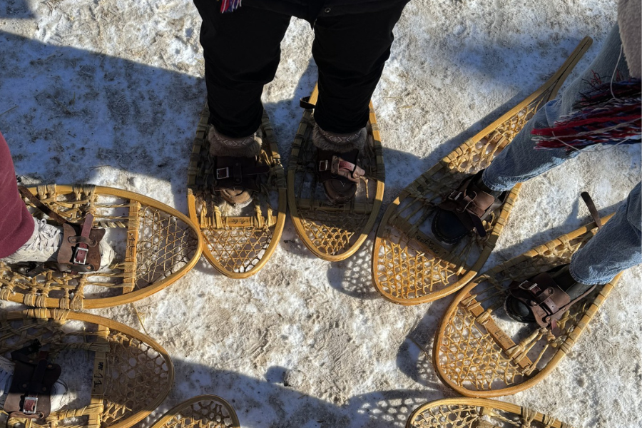 A group wearing snowshoes stands in a circle.