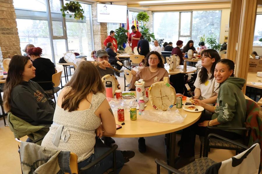 A group of participants around a table making drums.