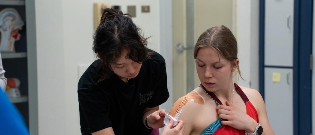 A woman doing a bandage demonstration on another student
