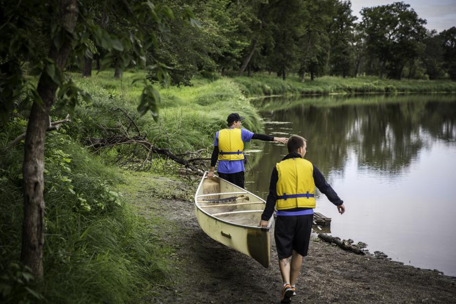 students carrying canoe