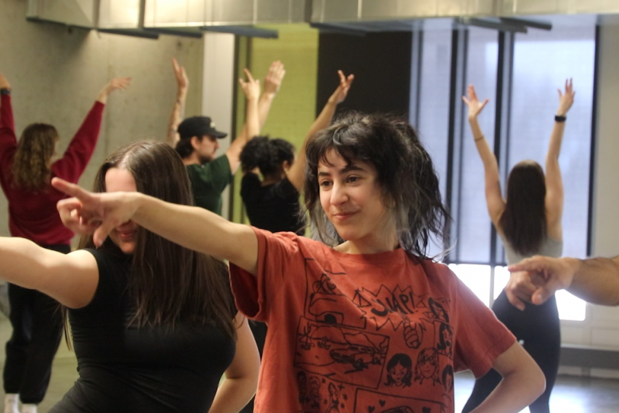 A student points during a dance class