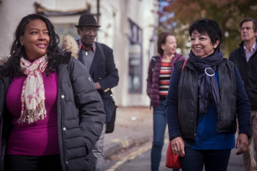 A group of adults walking outdoors and smiling