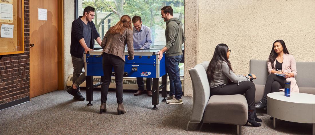 Students playing a game, while other students discuss the law at Robson Hall