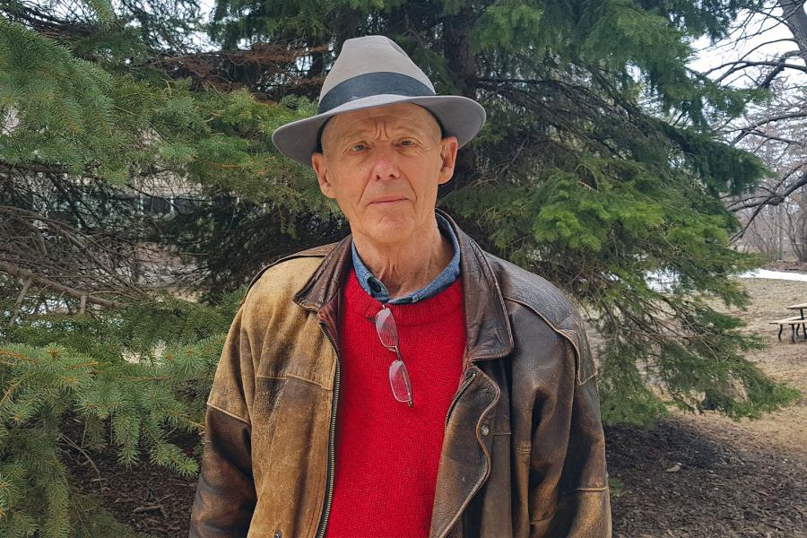 Professor Emeritus Cameron Harvey standing next to Robson Hall