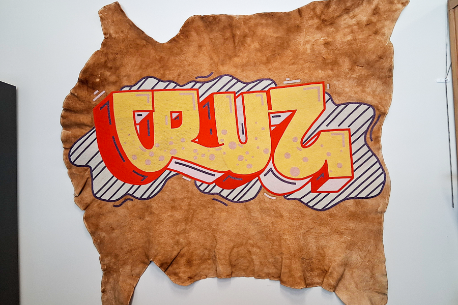 A beaded hide with the text "Cruz" in graffiti on it