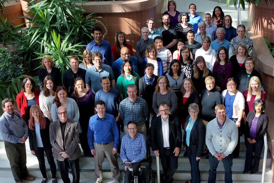 Large group photo from above in a sunlit atrium 
