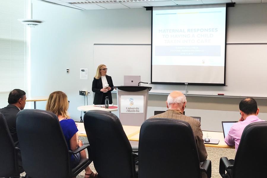 Student defending doctoral dissertation in front of panel of people 