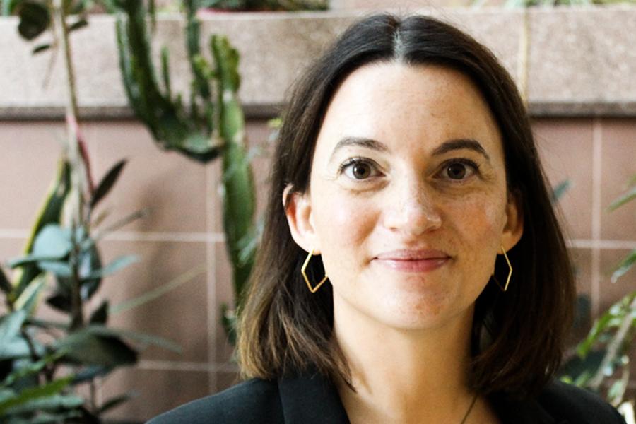 Maria Godoy smiling, standing in front of an indoor garden. 
