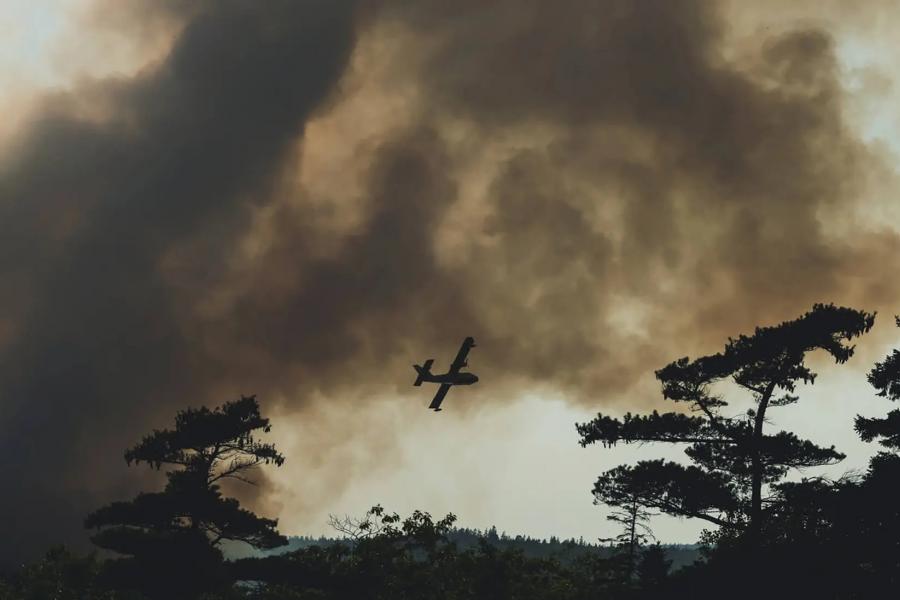 Photo of water bomber over smokey skies