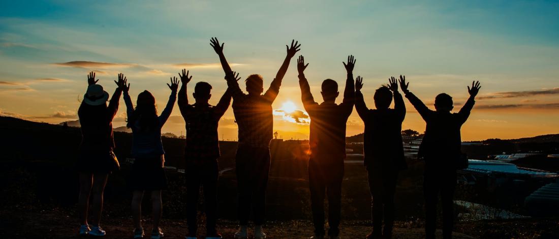 Group of people raising their hands in celebration.