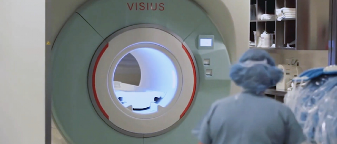 A healthcare worker facing a scanner.